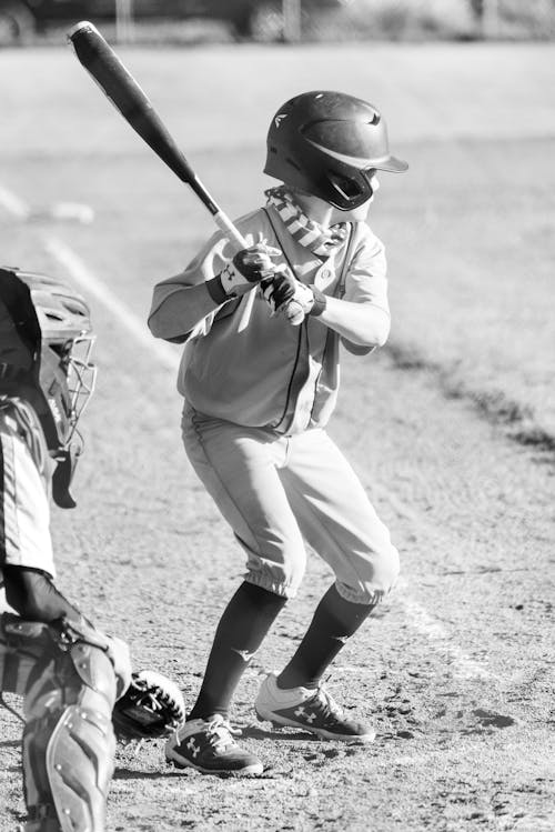 Grayscale Photography of a Boy Holding a Baseball Bat