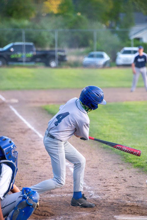 Boy in White Baseball Jersey and White Pants Playing Baseball