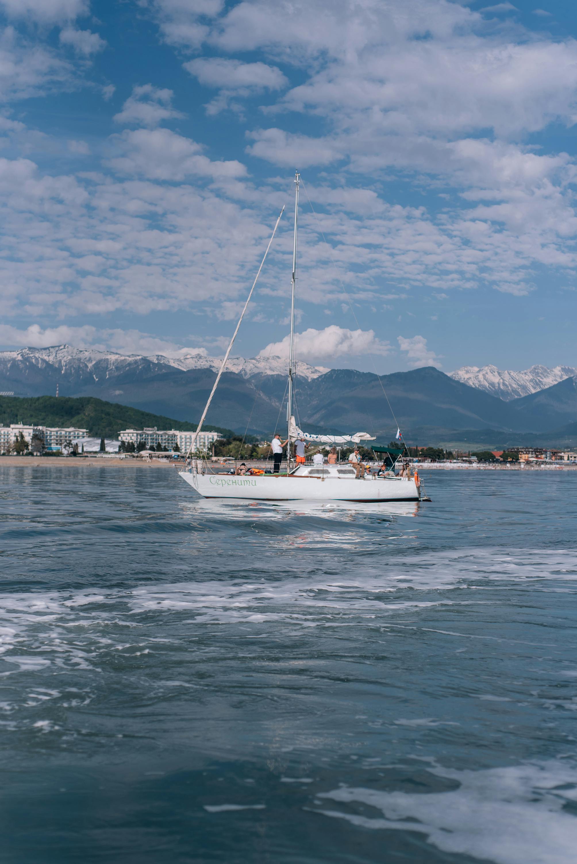 Free A sailboat glides across the Black Sea near Sochi, Russia, with snow-capped mountains in the background. Stock Photo