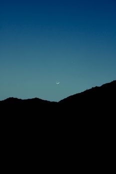 弦月和星星在黄昏时的山轮廓上方，营造出宁静的夜空景象。 - 相关推荐