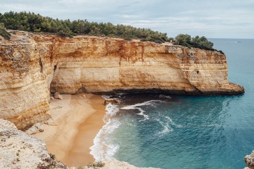 Free Beautiful coastal cliffs and beach at Praia da Corredoura, Portugal; serene and picturesque. Stock Photo