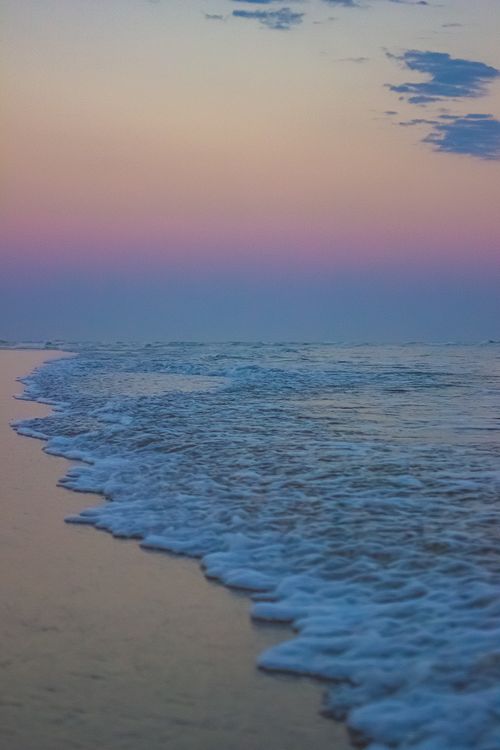 Free Peaceful ocean waves under a colorful twilight sky in Santa Catarina, Brazil. Stock Photo