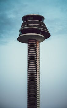 Modern air traffic control tower at Arlanda Airport against a blue sky.