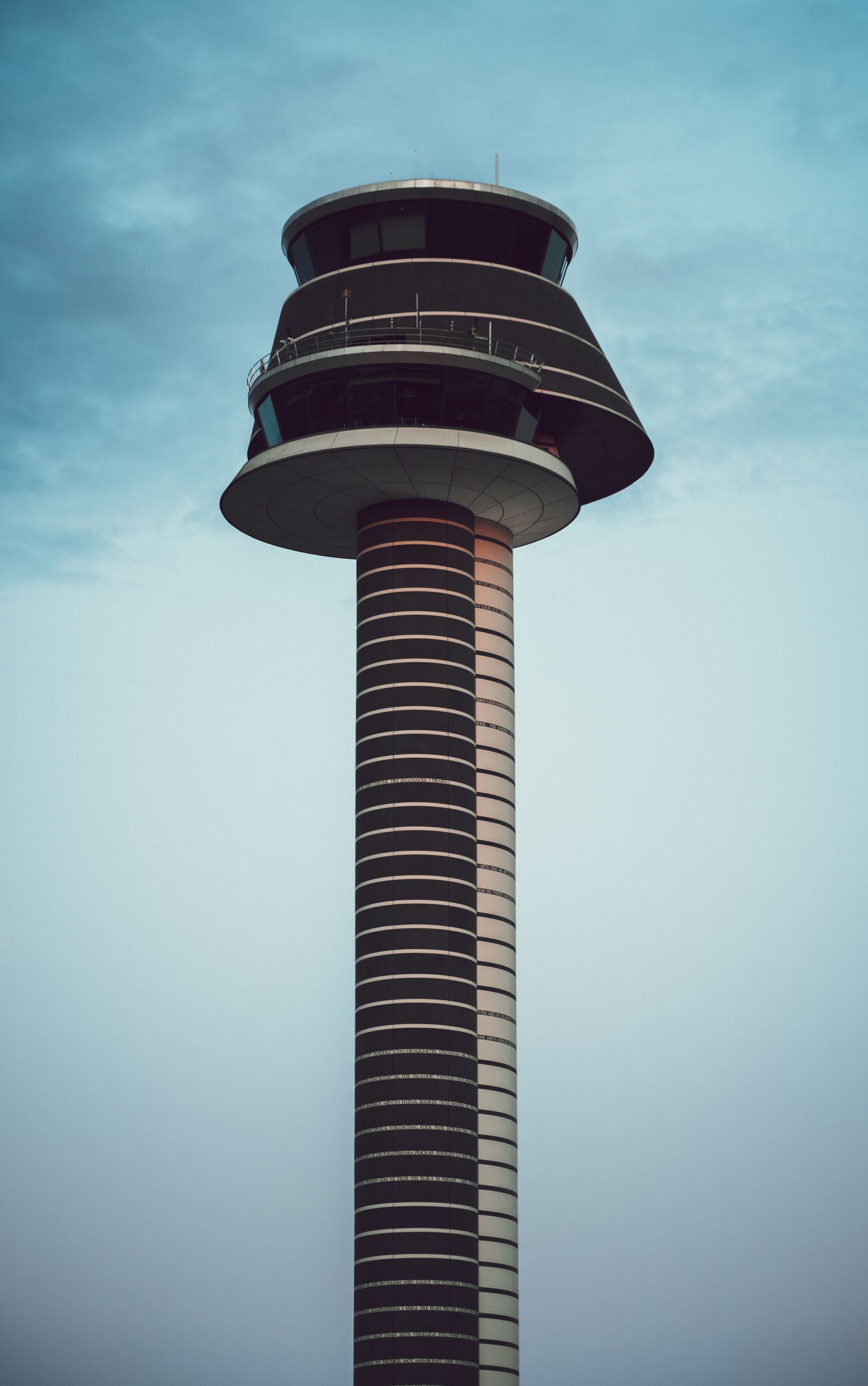 Air traffic control tower rising above an airport apron