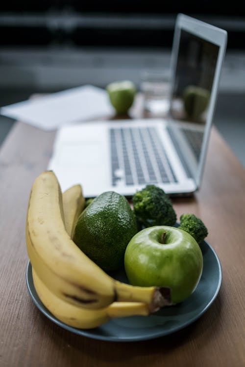 Gratis lagerfoto af bærbar computer, bananer, broccoli Lagerfoto