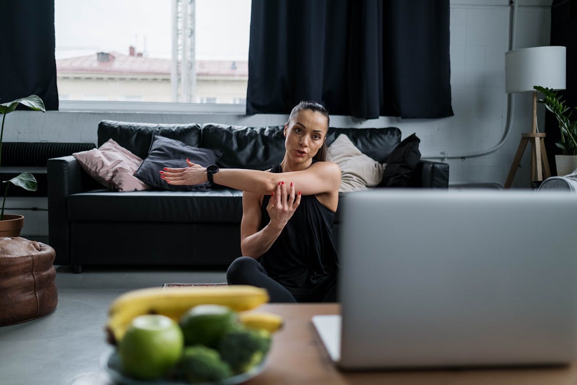 Free Woman in Black Tank Top Stretching Her Arm Stock Photo