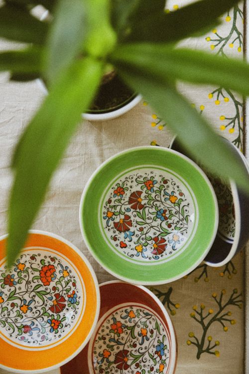 Free Top view of vibrant, hand-painted floral bowls on embroidered tablecloth. Stock Photo