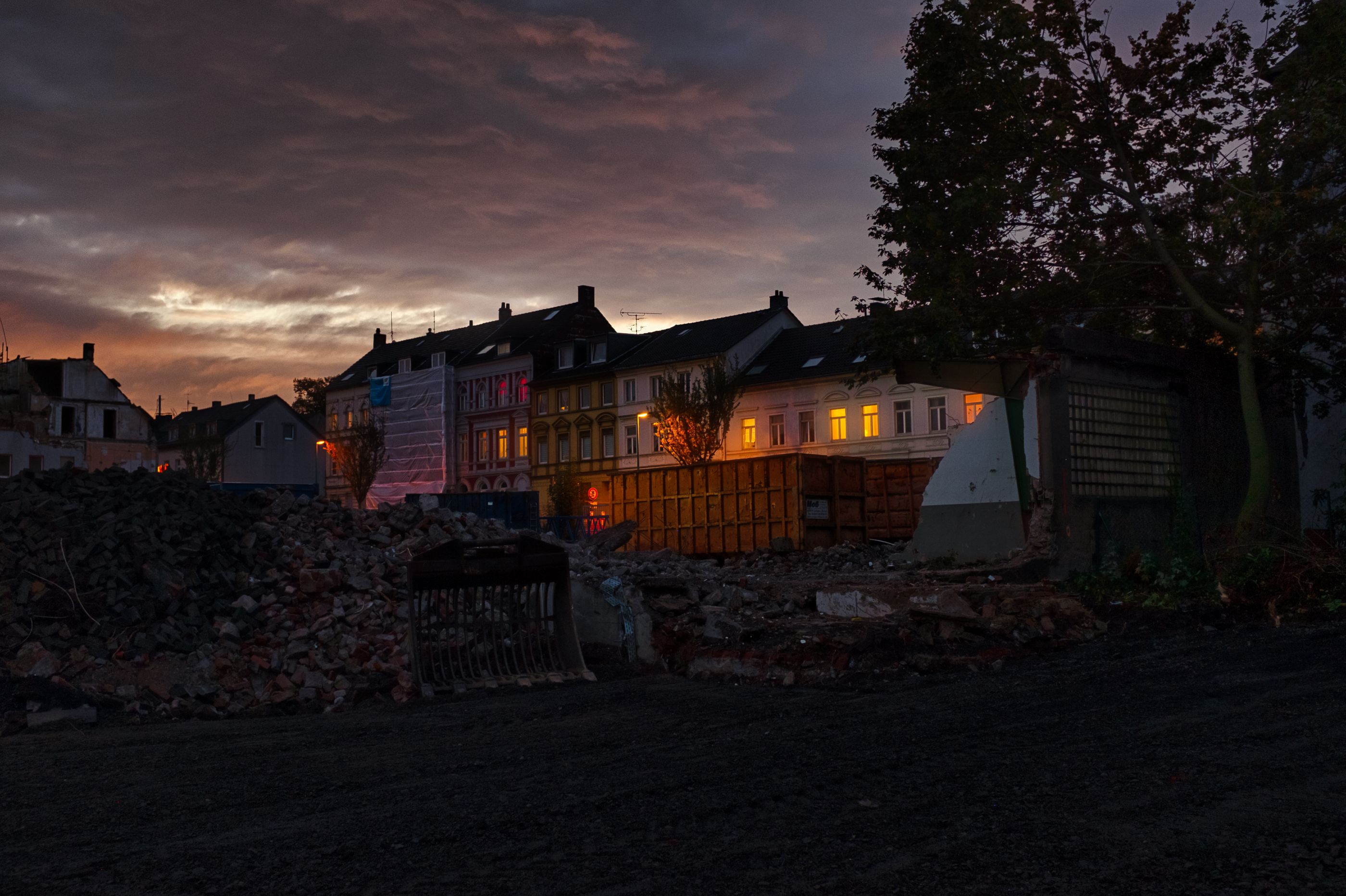 A residential street with rubble at dusk