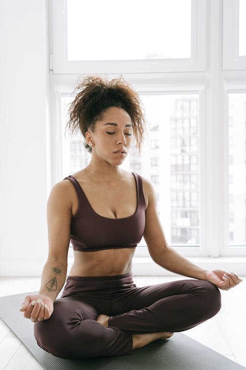 Free Beautiful Woman Practicing Meditation on Yoga Mat Stock Photo