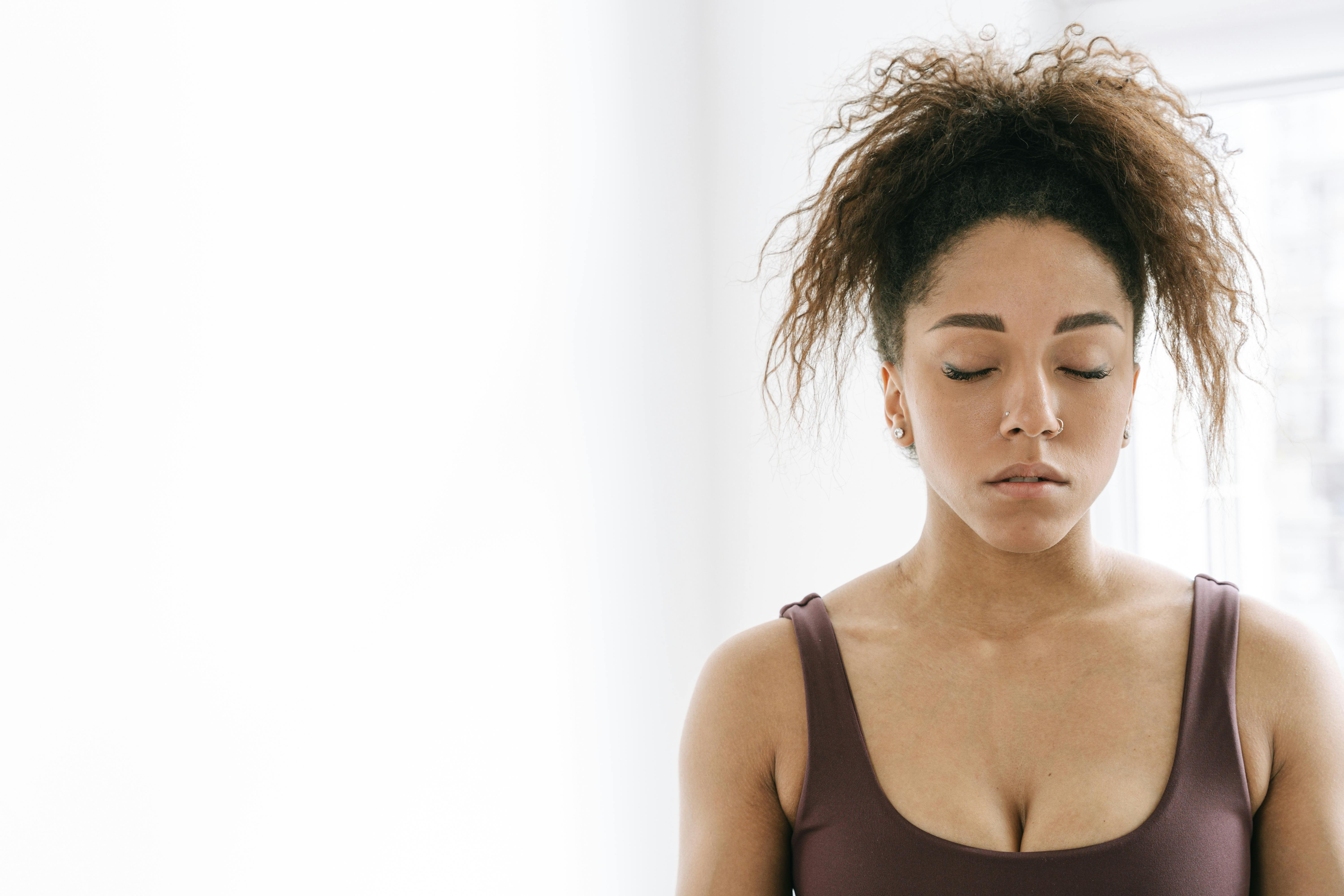 一个卷发的女人闭着眼睛在室内安静地冥想