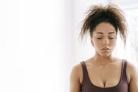 一个卷发的女人闭着眼睛在室内安静地冥想