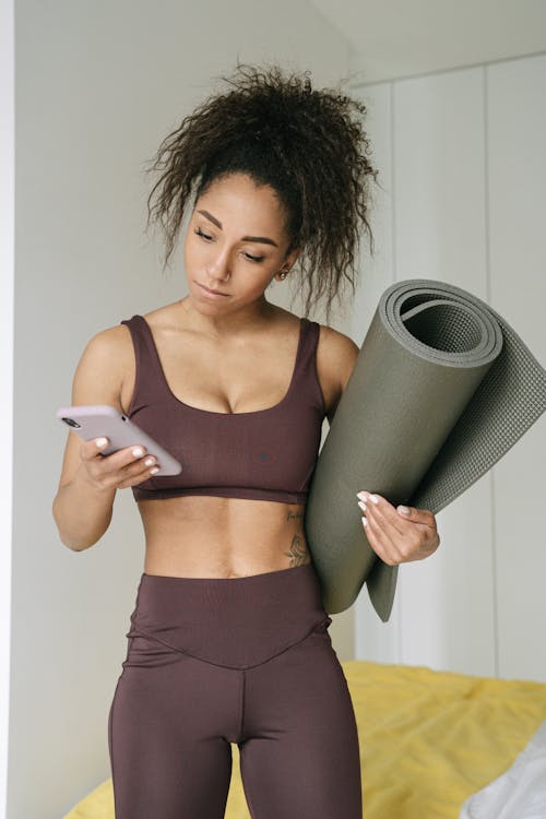 A Fit Woman Looking at Her Smartphone 