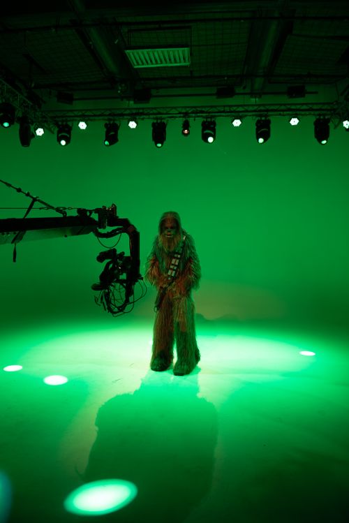 Free Star Wars character Chewbacca stands in a green-lit studio during film production. Stock Photo