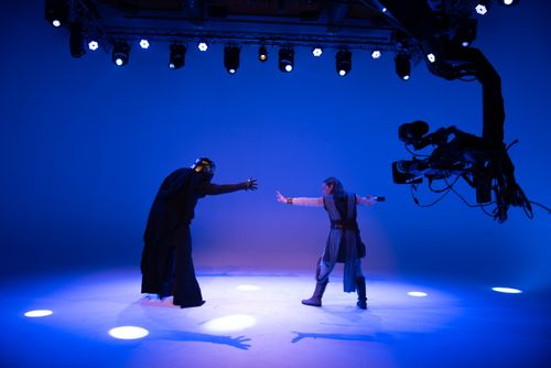 Free Actors perform a sci-fi scene under bright studio lights with advanced filming technology. Stock Photo