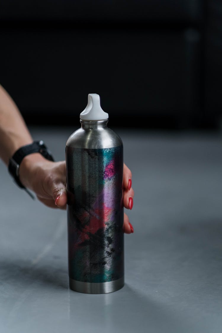 Hand Of A Woman Picking Up An Insulated Drink Container