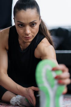 Woman engaging in a stretching exercise at a fitness center, showcasing her healthy lifestyle.