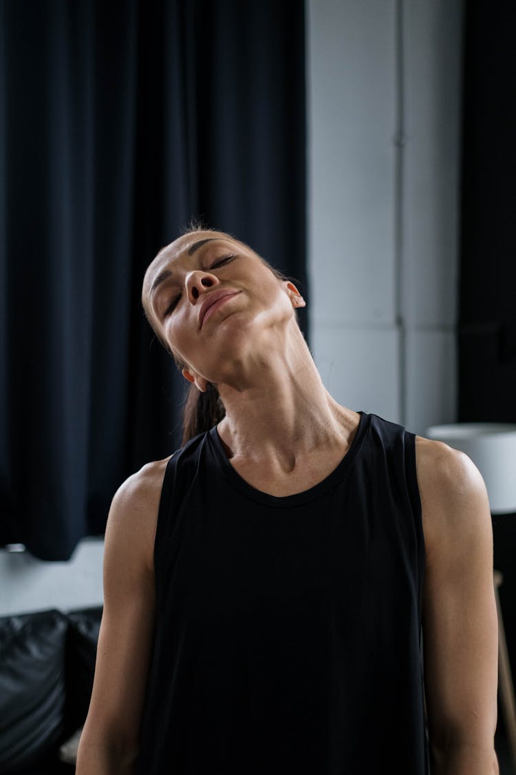 Woman In Black Tank Top Stretching Her Neck