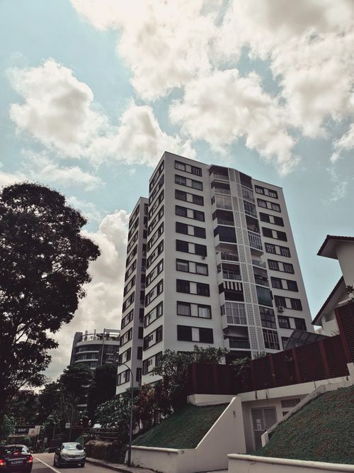 Free Multi-story residential building set against a blue sky in Singapore. Stock Photo