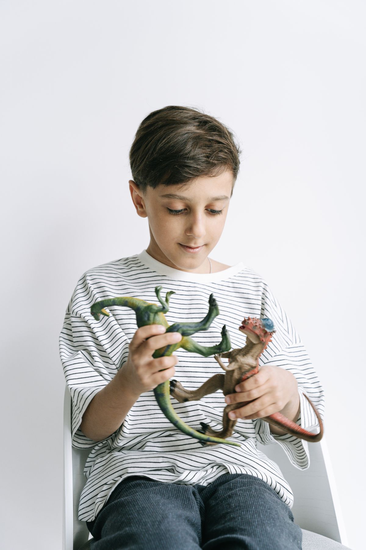 Boy playing with dinosaur toys for dinosaur crafts for kids
