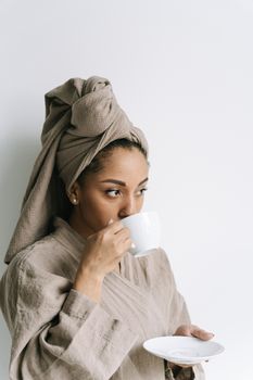 Woman in bathrobe enjoys morning coffee, creating peaceful moments.