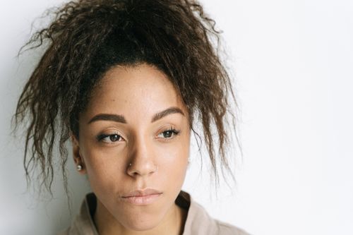 Free Close-up portrait of a young woman with nose piercings, looking thoughtful. Stock Photo