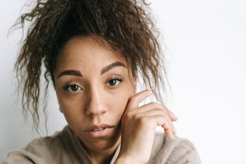 Free Intimate close-up portrait of a woman with curly hair and thoughtful expression. Stock Photo