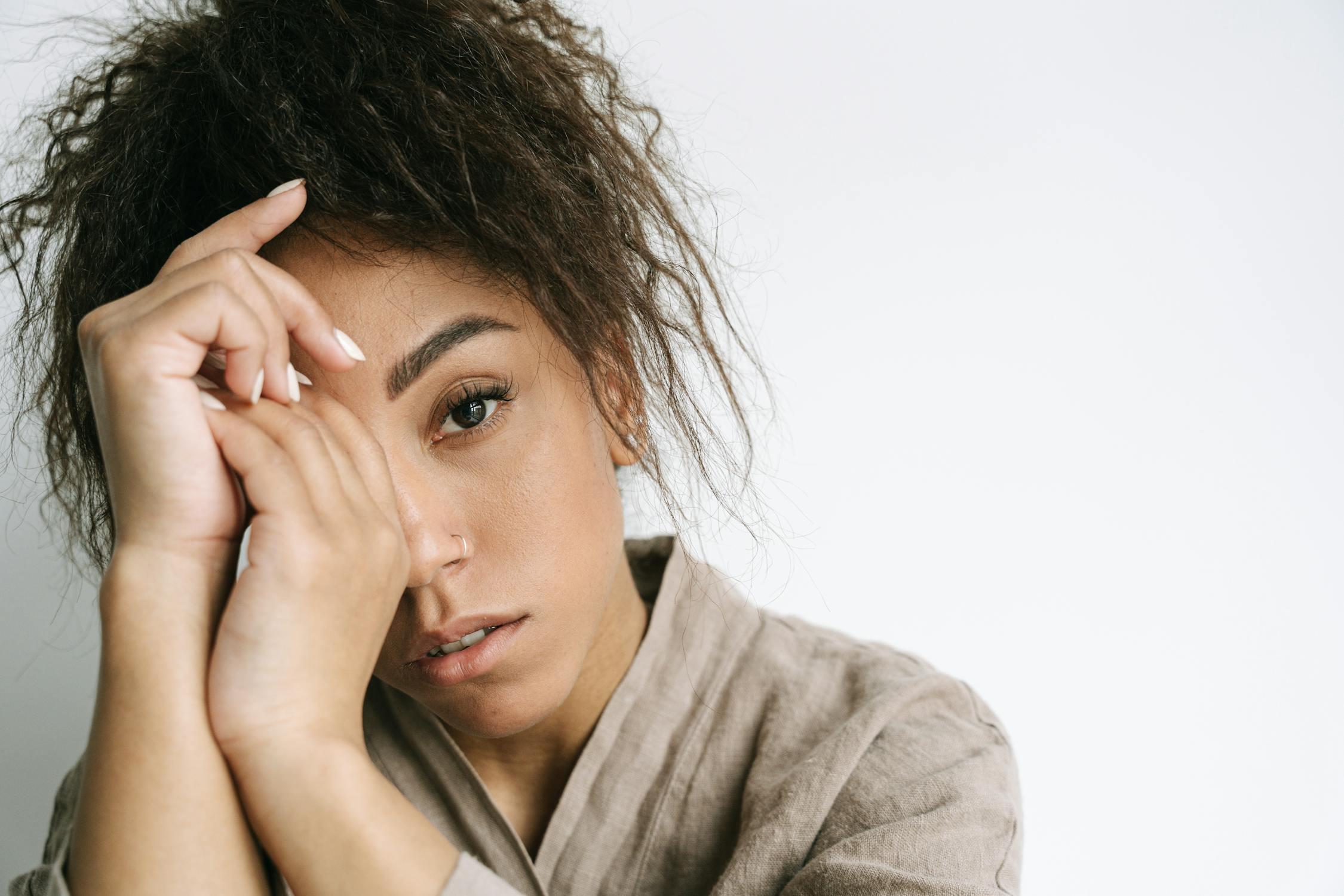 Close-Up Shot of a Curly-Haired Woman on White Background
