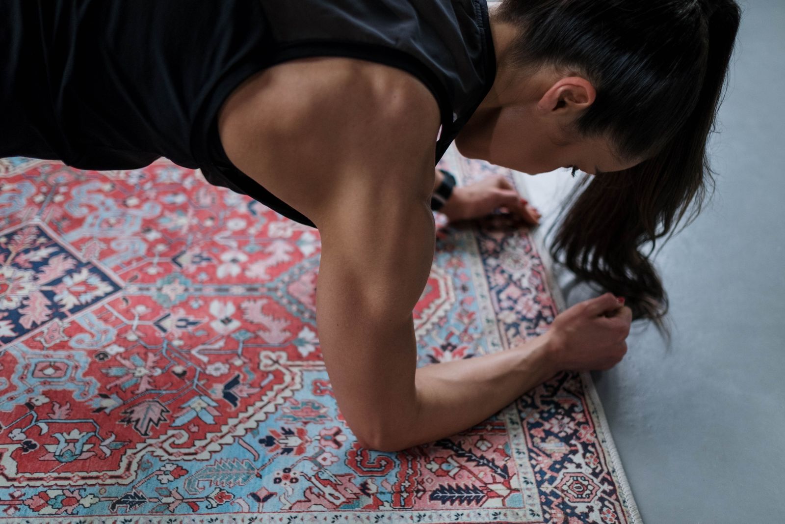 Woman practicing an arm-strengthening yoga plank pose on a mat