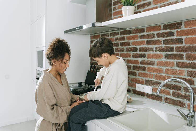 Mother And Son Cooking At The Kitchen