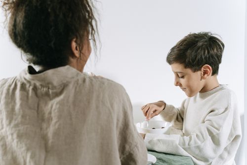 Free A warm moment captured of a mother and child sharing breakfast at home. Stock Photo