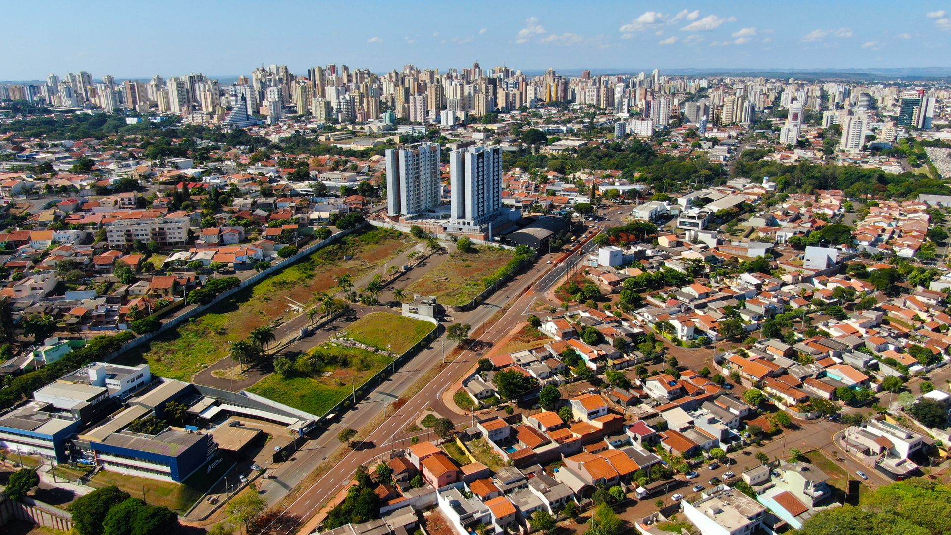 Aerial view of Londrina's cityscape featuring high-rise buildings and residential areas under a clear sky.