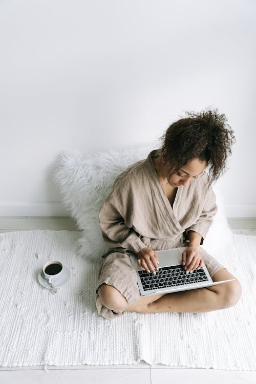 Free A Woman in a Robe Using Her Laptop Stock Photo