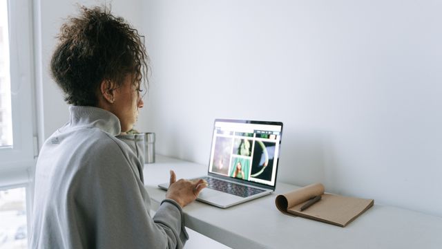 Mulher usando um notebook em uma mesa de trabalho.