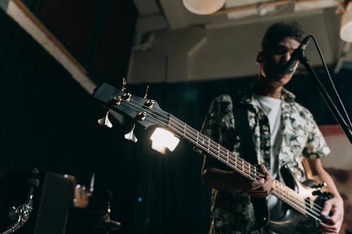 
A Man Playing a Bass Guitar while Singing