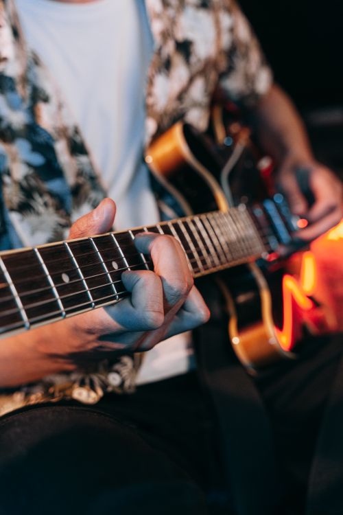 Free A musician skillfully playing an electric guitar during a live performance, creating a vibrant musical atmosphere. Stock Photo