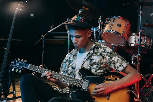 Man Sitting on the Stage Playing an Electric Guitar