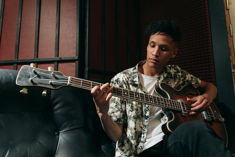 
A Man In A Floral Shirt Playing A Bass Guitar