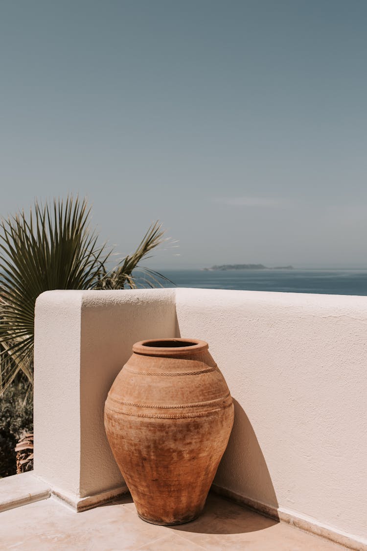 Brown Clay Pot In The Corner Of White Concrete Wall