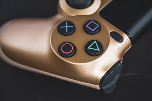 Detailed shot of a gold gaming controller with iconic buttons. Perfect for tech and gaming stock images.