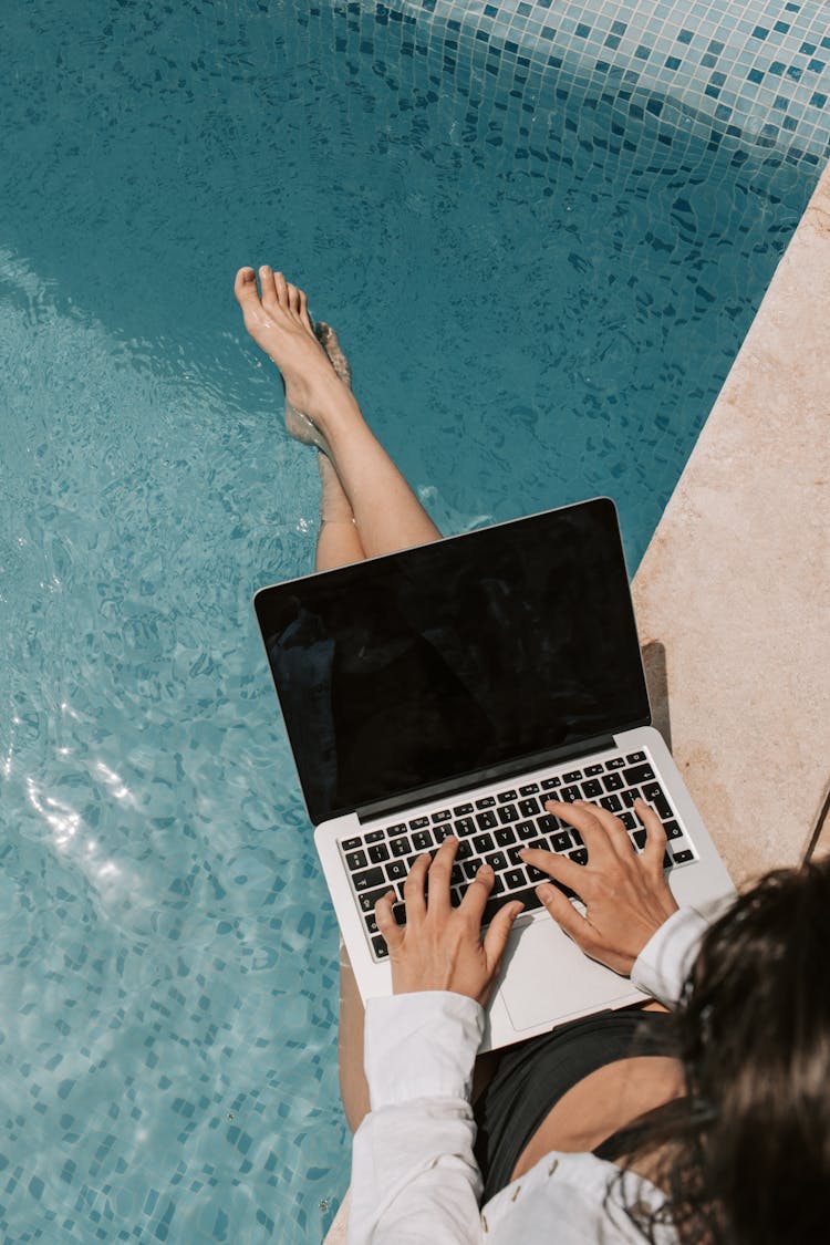 Woman Using Macbook By The Pool