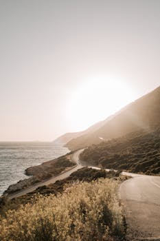 Breathtaking view of a coastal road in Antalya, Turkey with a radiant sunset over the ocean.