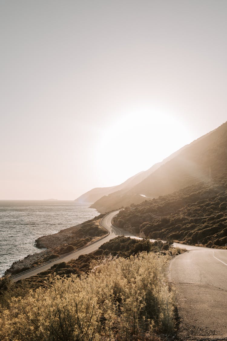 Coastal Road With View Of Sunset Over The Mountain