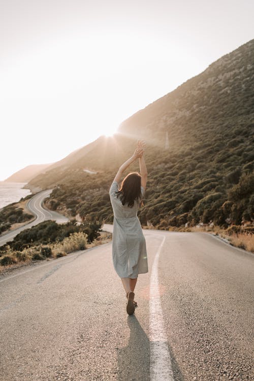 Woman Standing In The Middle Of A Road Feeling Free