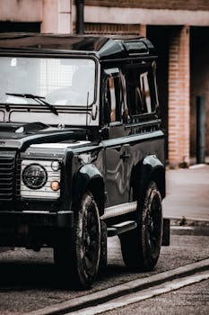 Close-up of a luxury black SUV on a city street, showcasing its sleek design.