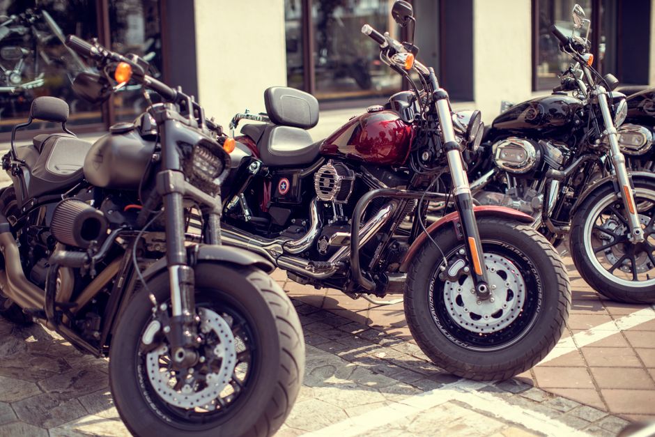 Close-up of three motorcycles parked on a city sidewalk, showcasing urban transportation.