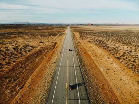 Aerial shot of motorcyclists riding through the vast desert landscapes of Utah.