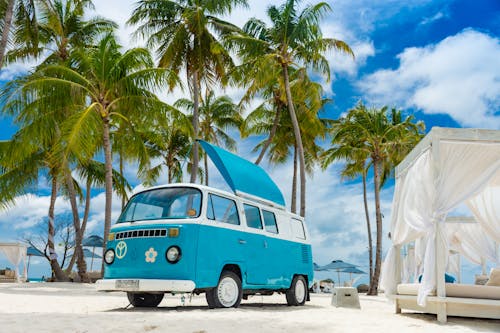 Free Vintage camper on beach under palms Stock Photo