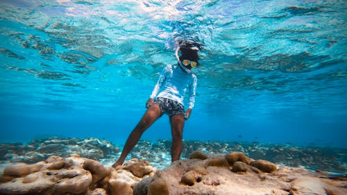 Unrecognizable woman snorkeling underwater