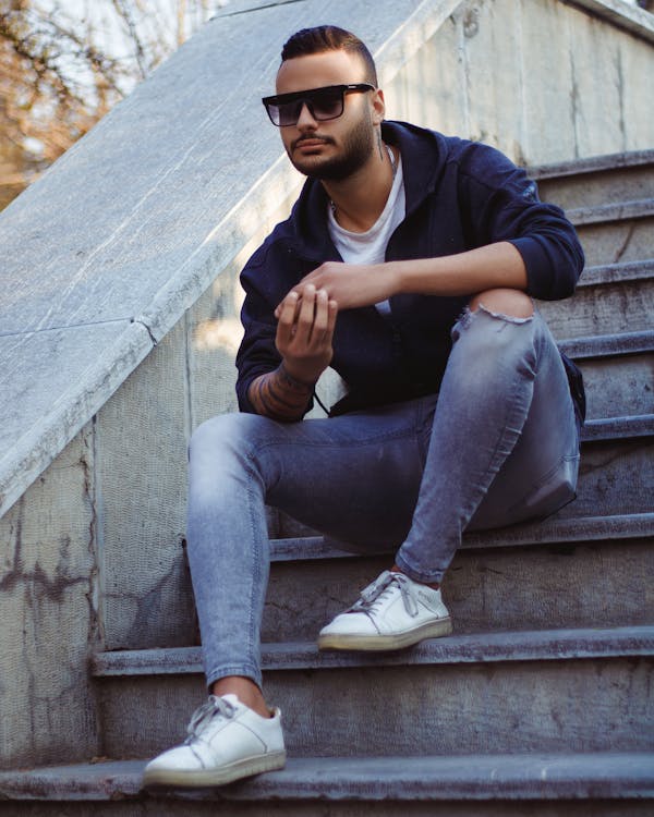 Portrait of a Male Fashion Model Wearing Sunglasses and Torn Jeans