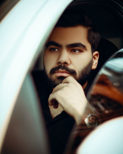 Free Portrait of a young man with a beard sitting in a car contemplating. Stock Photo